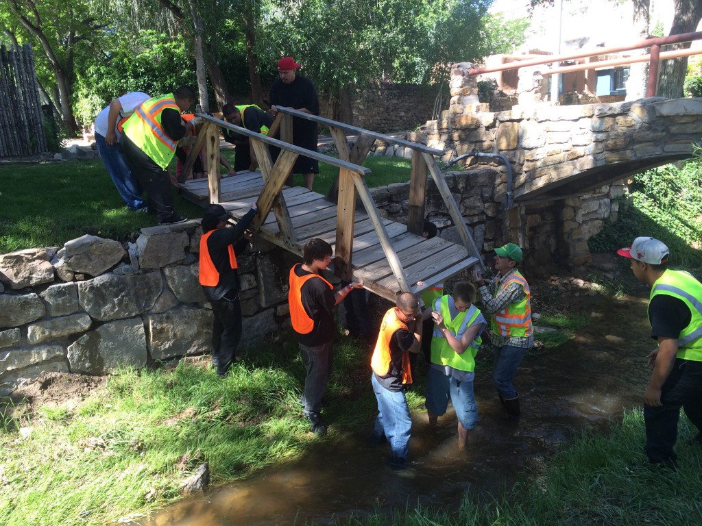 ¡YouthWorks! river restoration crew installs a bridge across the Santa Fe River.
