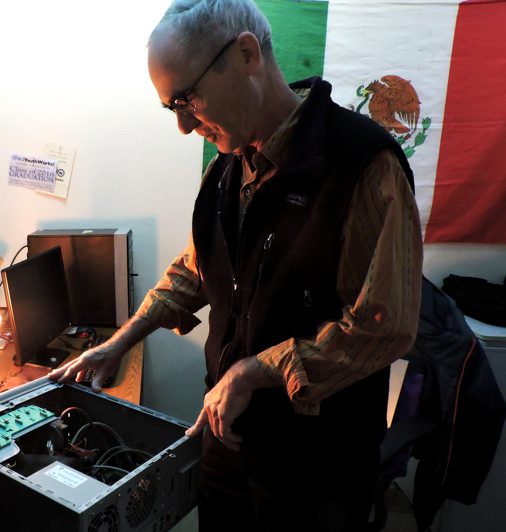 Volunteer repairs computer equipment at ¡YouthWorks!