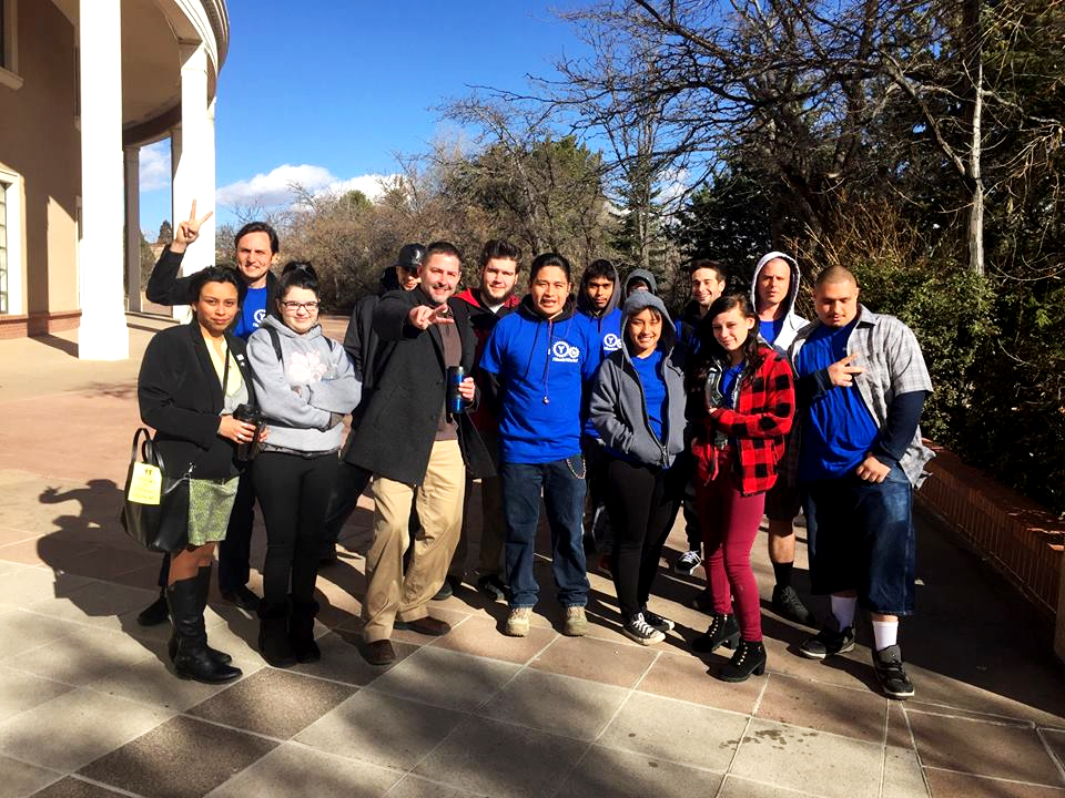 A crew from ¡YouthWorks! poses for a photo outside the New Mexico State Capitol..